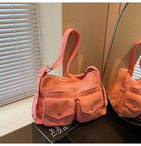 Détail du sac cabas en velours côtelé corail avec deux poches frontales et boucle en métal