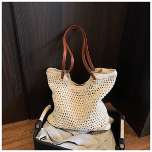 Detail of hollow woven tote bag featuring premium brown faux leather handles and rivets