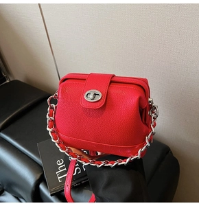 Detail of red lychee grain leather bucket bag featuring a silver twist lock closure