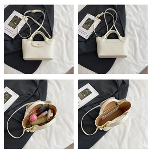 Detailed interior of mini white leather tote bag showing storage capacity and inner pocket