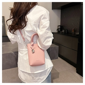 Mini sac seau rose en cuir grainé avec pendentif en forme de cœur argenté brillant