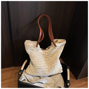 Macro view of woven mesh texture and brown leather handle with metal rivet on tote bag