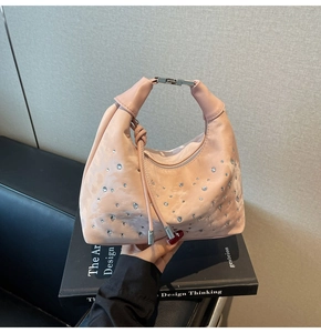 Detailed view of pink rhinestone hobo bag with sparkling crystals and silver buckle