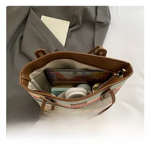 Spacious interior of striped woven beach tote with brown leather handles and inner pocket