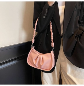 Detail of pink pleated hobo bag with woven handle and metallic silver hardware
