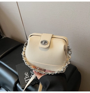 Detail of cream textured leather doctor bag with silver buckle and chain strap