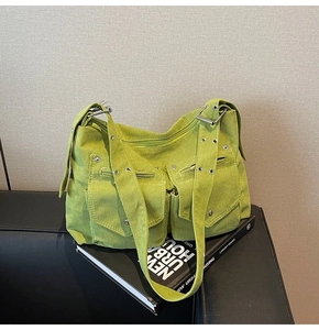 Détail du sac cabas en velours côtelé vert avec poches avant et bandoulière à œillets