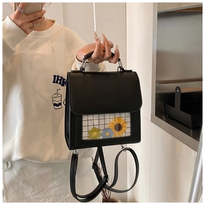 Detail view of mini black leather backpack with floral PVC window and black checkered liner