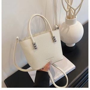 Detail of cream white lychee grain bucket bag with silver beads and fashion lettering
