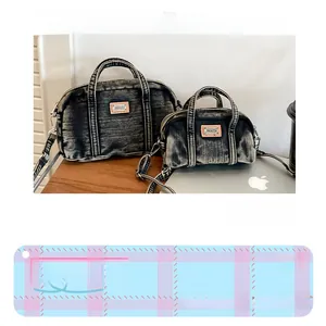 Gros plan sur l'ensemble de sacs en denim délavé avec bandoulière et écusson en cuir