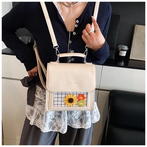 Detail of cream white PU crossbody bag featuring 3D sunflower mesh pocket and flap handle