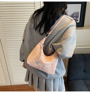 Detail of light pink rhinestone hobo bag with pleated texture and thin shoulder strap