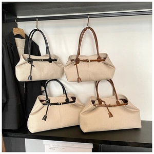 Close-up of minimalist canvas tote bags in various sizes with black and brown leather straps