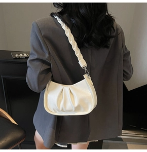 Detail of white pleated cloud bag with chunky braided strap and silver metal hardware