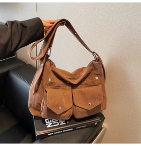 Texture détaillée du sac hobo en velours côtelé marron avec poches à boucle en métal