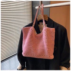 Detail of pink hand-crocheted tote bag with mesh texture and faux leather handles