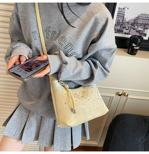 Detail of light yellow rhinestone crossbody bag with knotted strap and crystal embellishments
