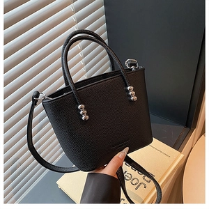 Close-up of black pebble leather bucket bag with silver hardware and round handle