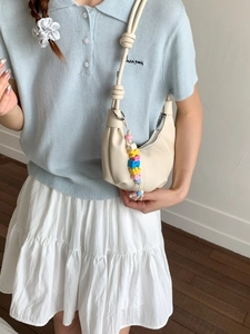 Chic cream white pleated crescent bag with knotted strap and colorful bead charm