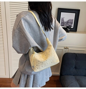 Detailed view of pale yellow pleated shoulder bag with sparkling rhinestone surface