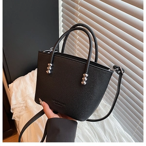 Detail of black lychee grain leather bucket bag with silver bead hardware handle