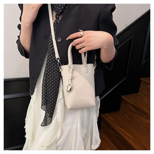 Détail du mini sac à main crème avec texte FASHION et breloque en forme de cœur