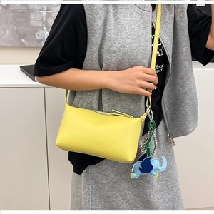 Dettaglio della borsa gialla in pelle a grana con ciondolo a forma di elefante blu