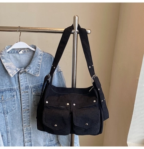 Détail du sac fourre-tout en velours noir avec poches avant et rivets argentés