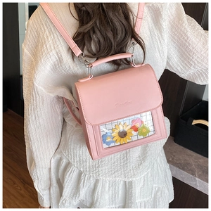 Detailed view of pink faux leather backpack featuring a transparent window with floral inserts
