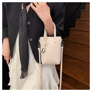 Détail du mini sac blanc cassé à grain de litchi avec pendentif coeur en argent