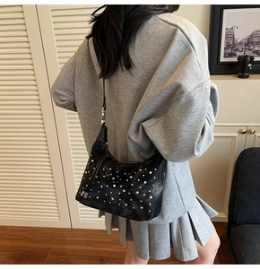 Detailed view of shimmering silver rhinestones on a stylish black pleated shoulder bag