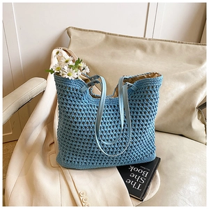 Detail of blue crochet tote bag showing hollow knit pattern and leather shoulder straps