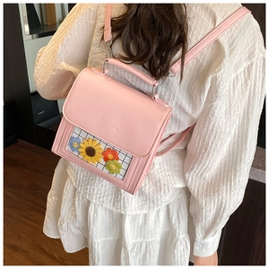 Detailed view of pink PU leather backpack featuring floral embroidery and transparent window