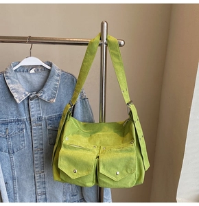 Détail du sac cabas en velours vert avec doubles poches utilitaires et boucles en métal