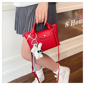 Red pebbled leather mini tote bag with gold metal buckle and white rabbit plush charm
