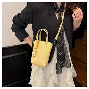 Détail du mini sac jaune en bandoulière avec pendentif cœur et finitions argent