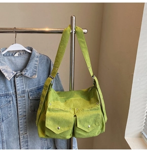 Détail du cabas en velours côtelé vert citron avec doubles poches et rivets en métal