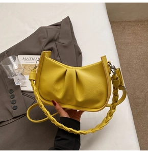 Detail of yellow hobo bag featuring lychee texture and thick woven shoulder strap