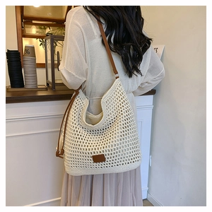 Detail of the woven crochet shoulder bag with brown leather straps in a casual style