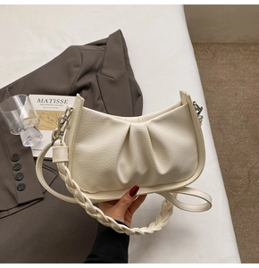 Detail of off-white pleated moon bag with lychee texture and woven handle
