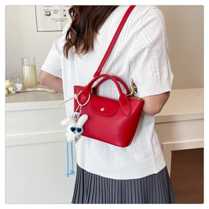 Detail of red lychee grain mini tote bag with a cute white bunny plush keychain