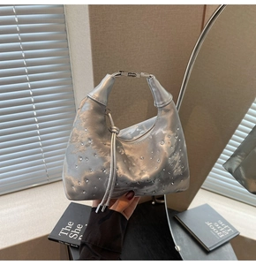 Detailed close-up of metallic silver hobo bag with sparkling rhinestone decorations