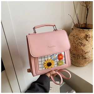 Detailed close-up of pink bag featuring a transparent window with colorful knitted flowers