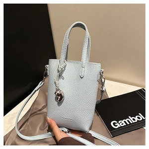 Détail du mini sac cabas bleu clair texturé litchi avec breloque cœur et imprimé mode