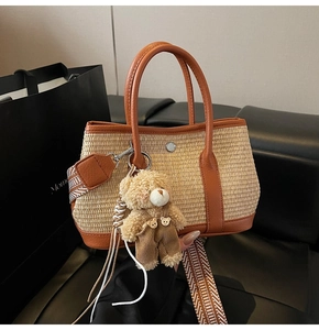 Détail du sac en paille avec bordure en cuir marron, bandoulière tissée et ours en peluche