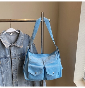 Gros plan sur un sac bandoulière en velours côtelé bleu clair avec deux poches avant