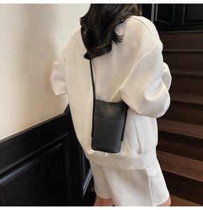 Minimalist black pebble grain PU leather crossbody mobile phone bag shown on a model