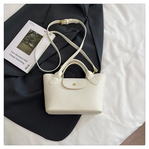 Chic cream white pebble leather mini tote bag with gold snap button on black blazer