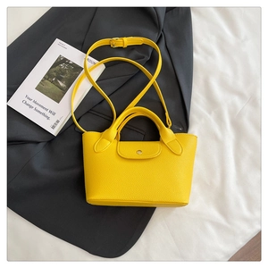 Detail of yellow mini tote bag with litchi grain texture and adjustable shoulder strap