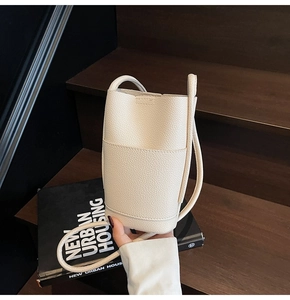 Detail of beige lychee grain leather mini crossbody bag with minimalist rectangular structure